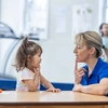 a nurse providing speech and language therapy for cleft palate to a little girl